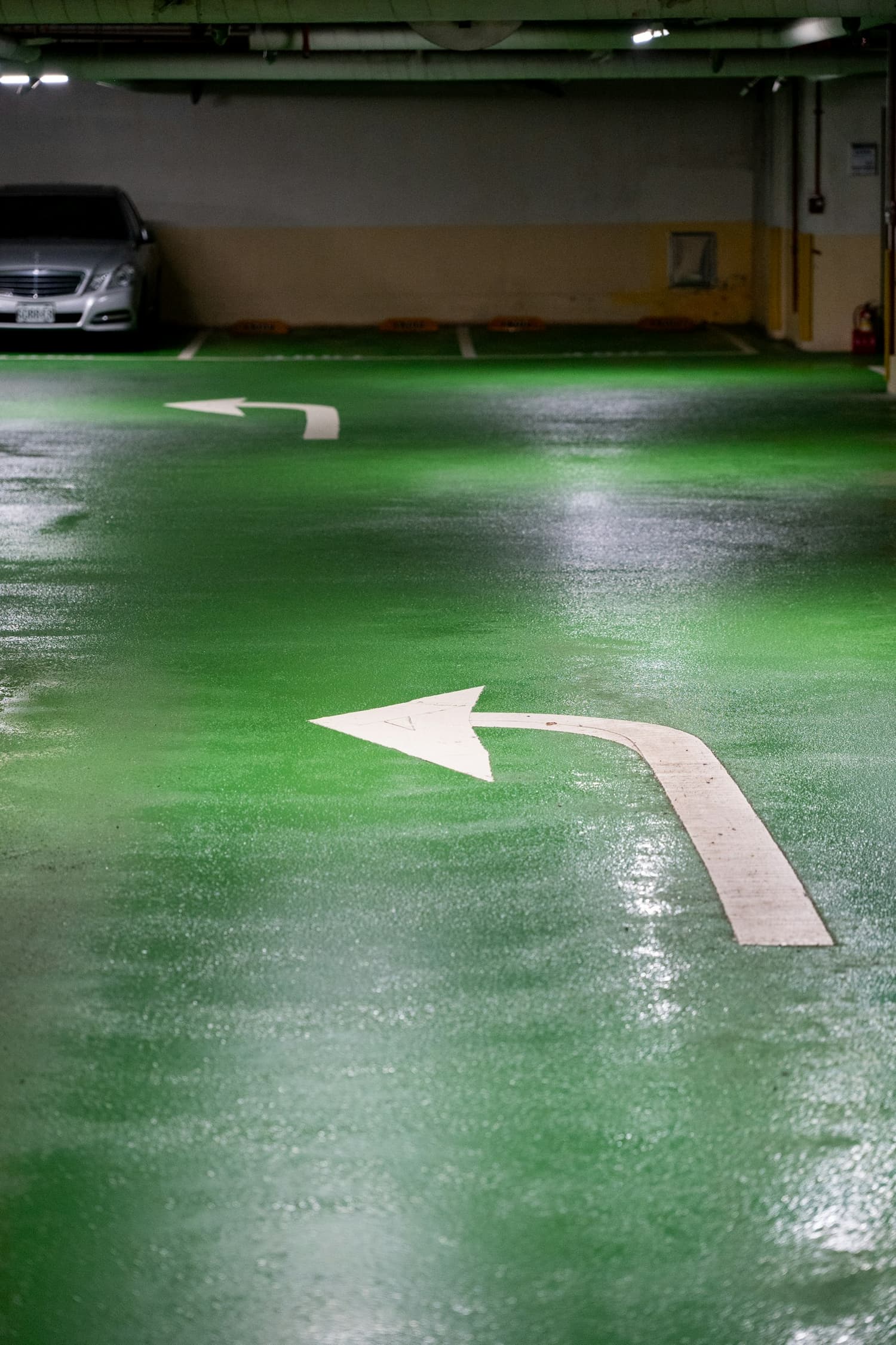 Glossy green decorative epoxy coated floor with painted directional arrow